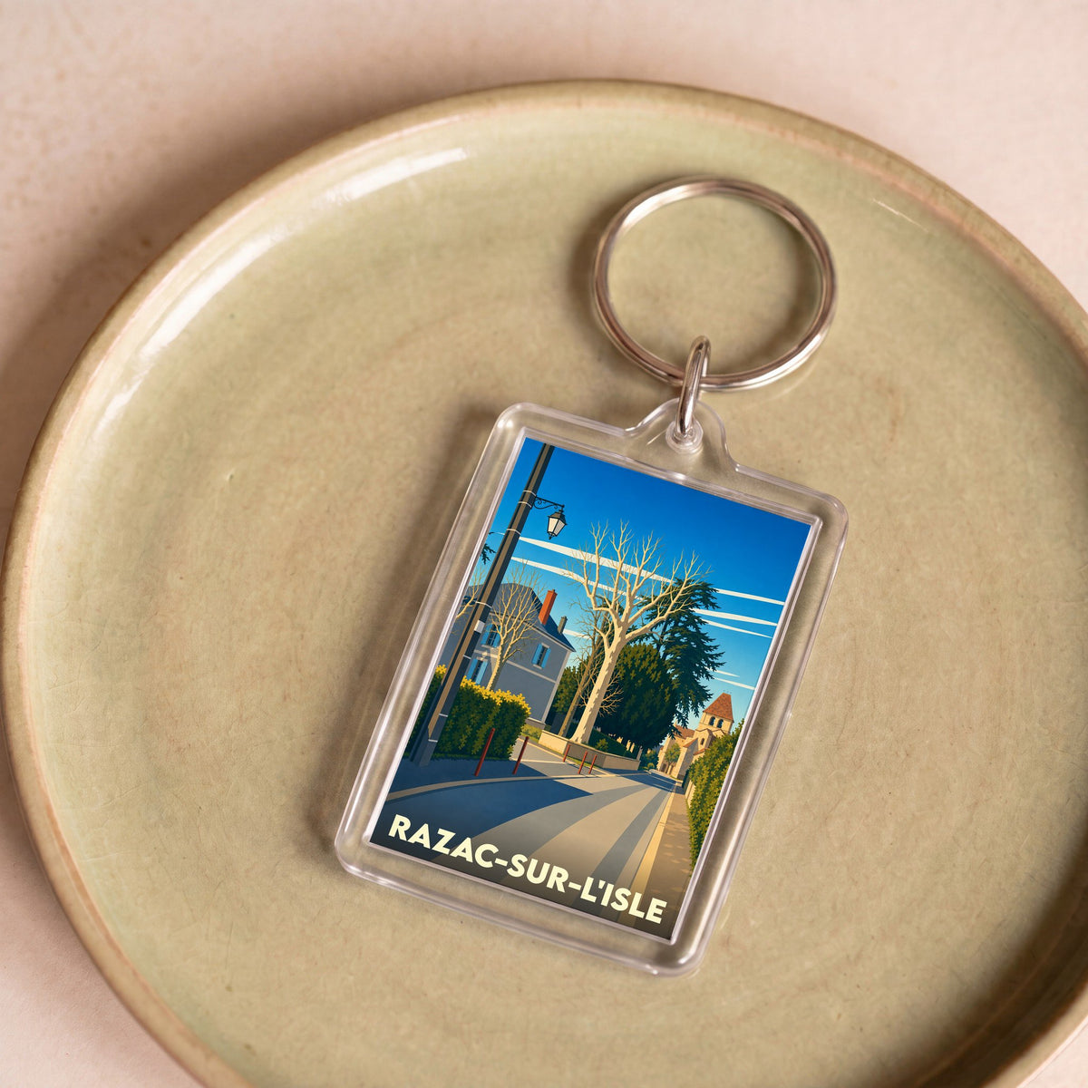 Porte-clés souvenir de la ville de Razac-sur-l'Isle avec une illustration stylisée.