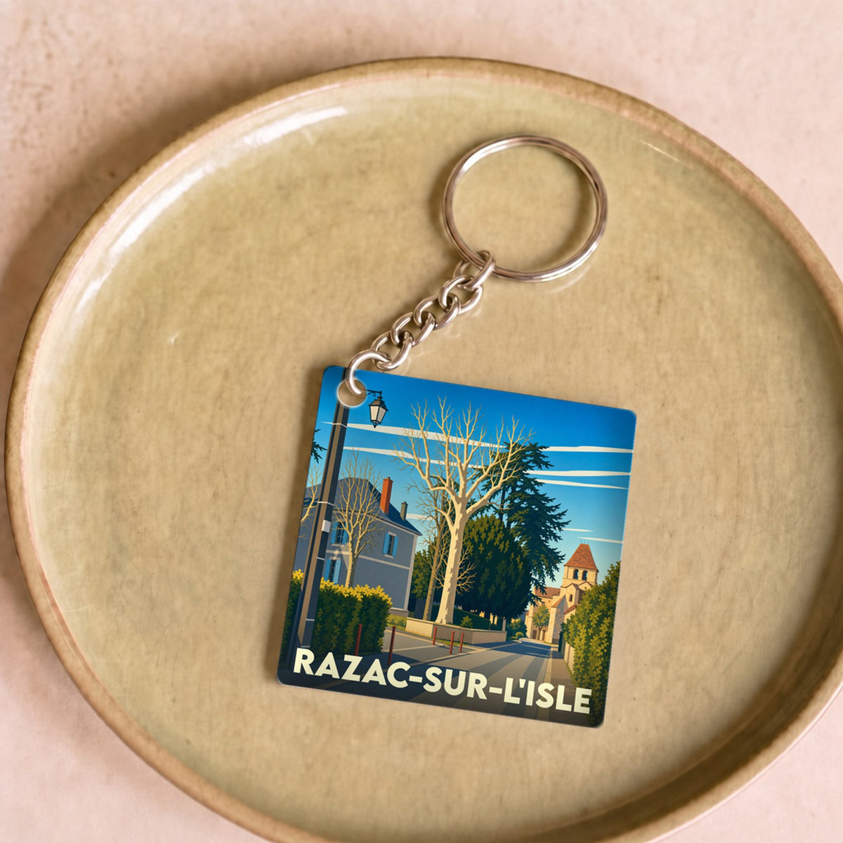 Porte-clés souvenir de la ville de Razac-sur-l'Isle avec une illustration stylisée.
