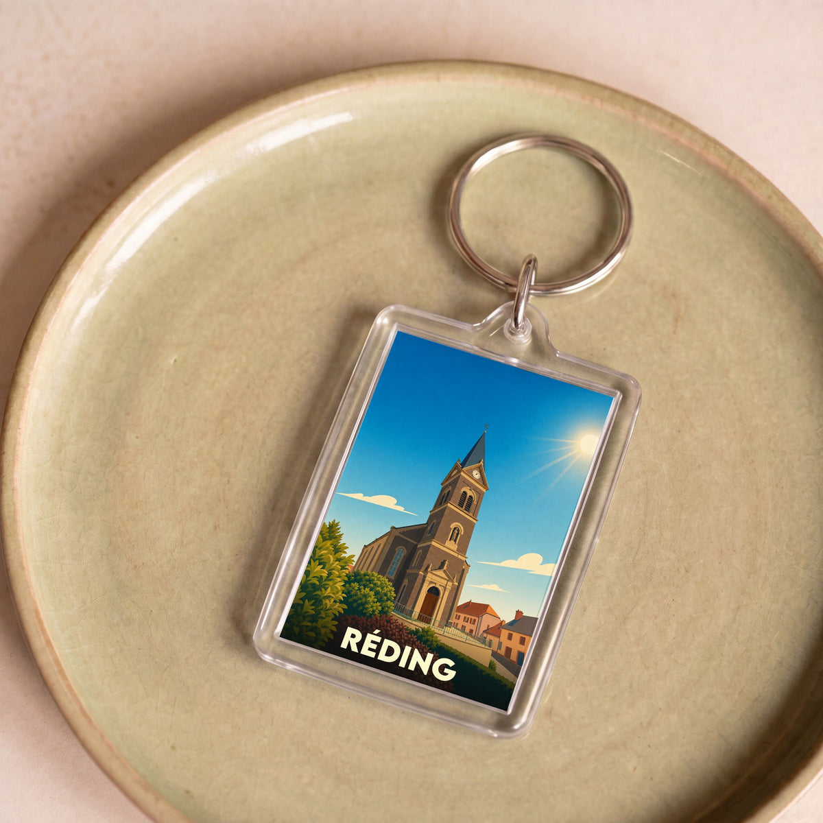 Porte-clés souvenir de la ville de Réding avec une illustration stylisée de son église.
