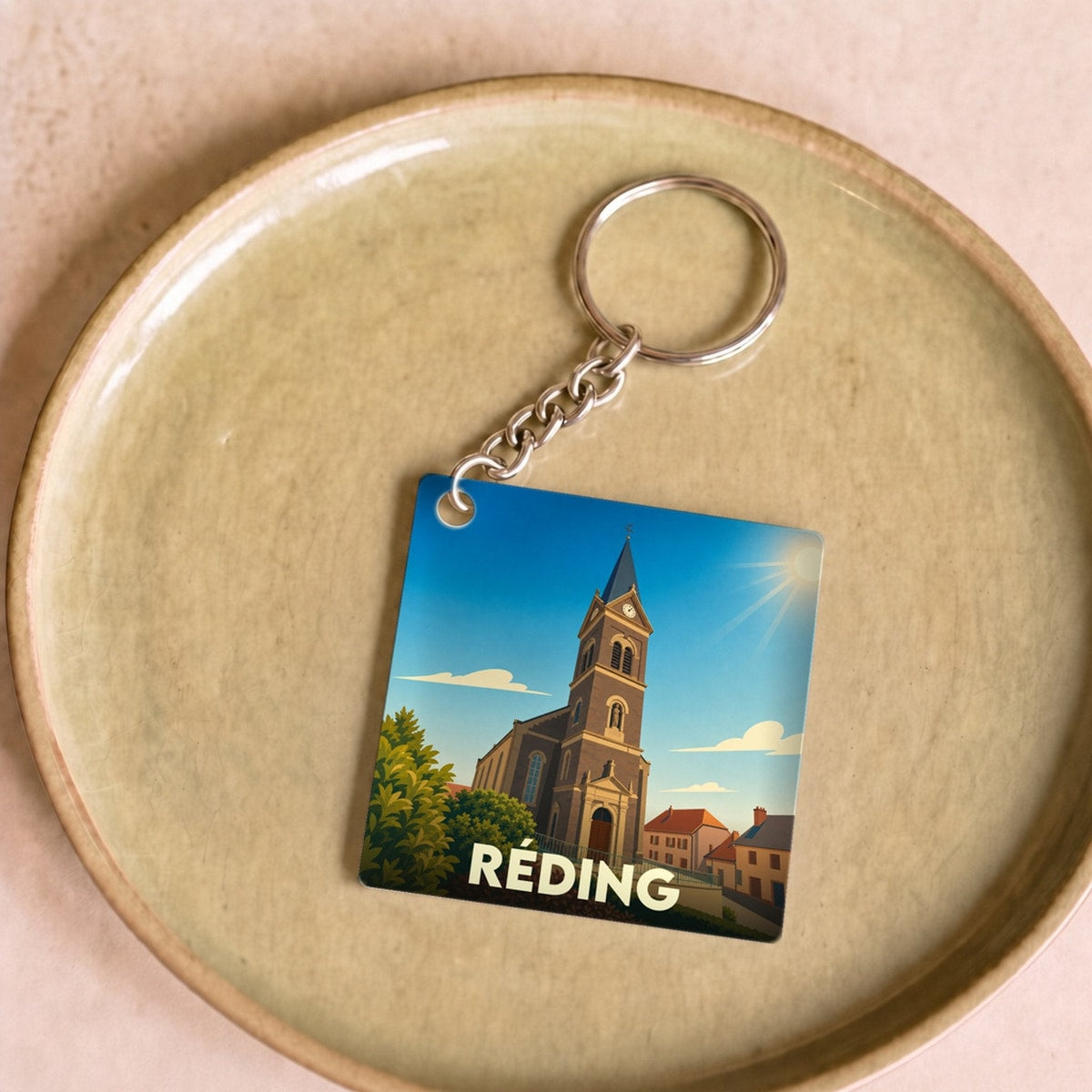 Porte-clés souvenir de la ville de Réding avec une illustration stylisée de son église.