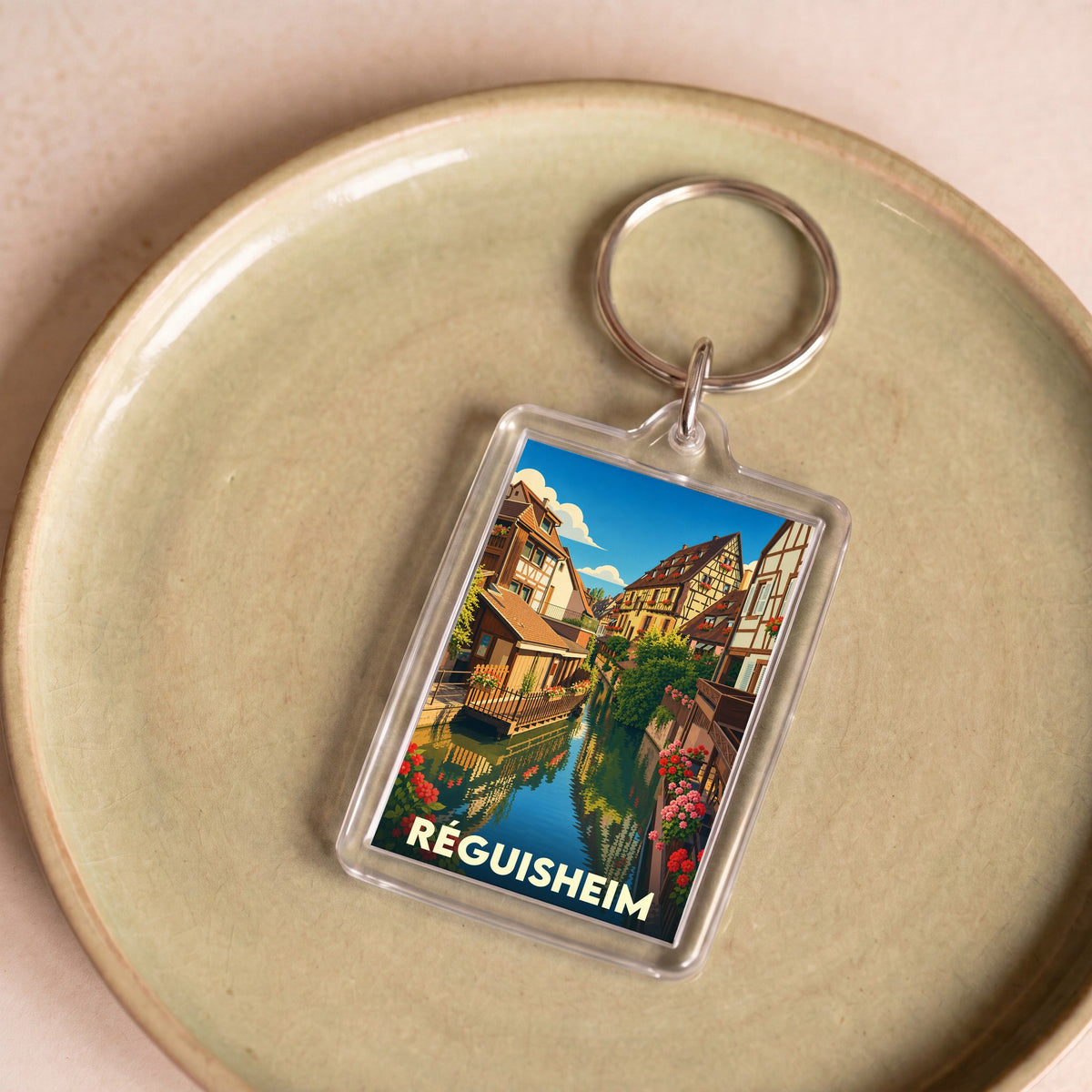 Porte-clés souvenir de la ville de Réguisheim avec une illustration stylisée.
