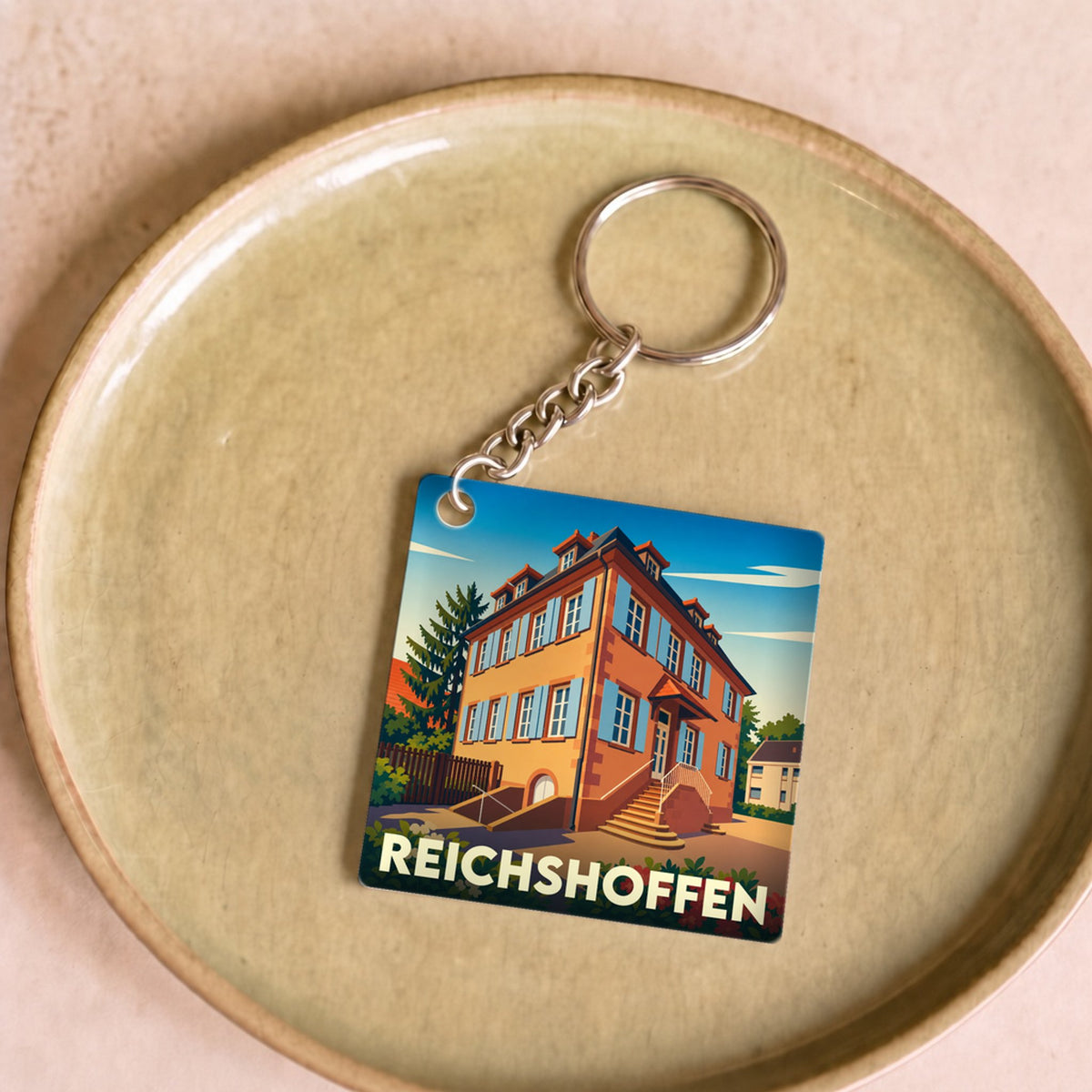 Porte-clés souvenir de la ville de Reichshoffen avec une illustration stylisée d'un bâtiment historique.