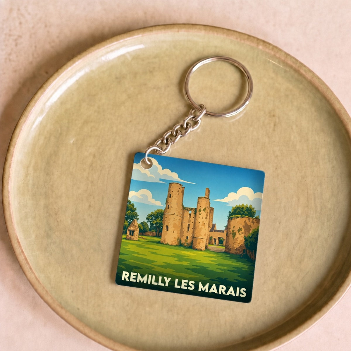 Porte-clés souvenir de la commune de Remilly Les Marais avec une illustration stylisée de son château.