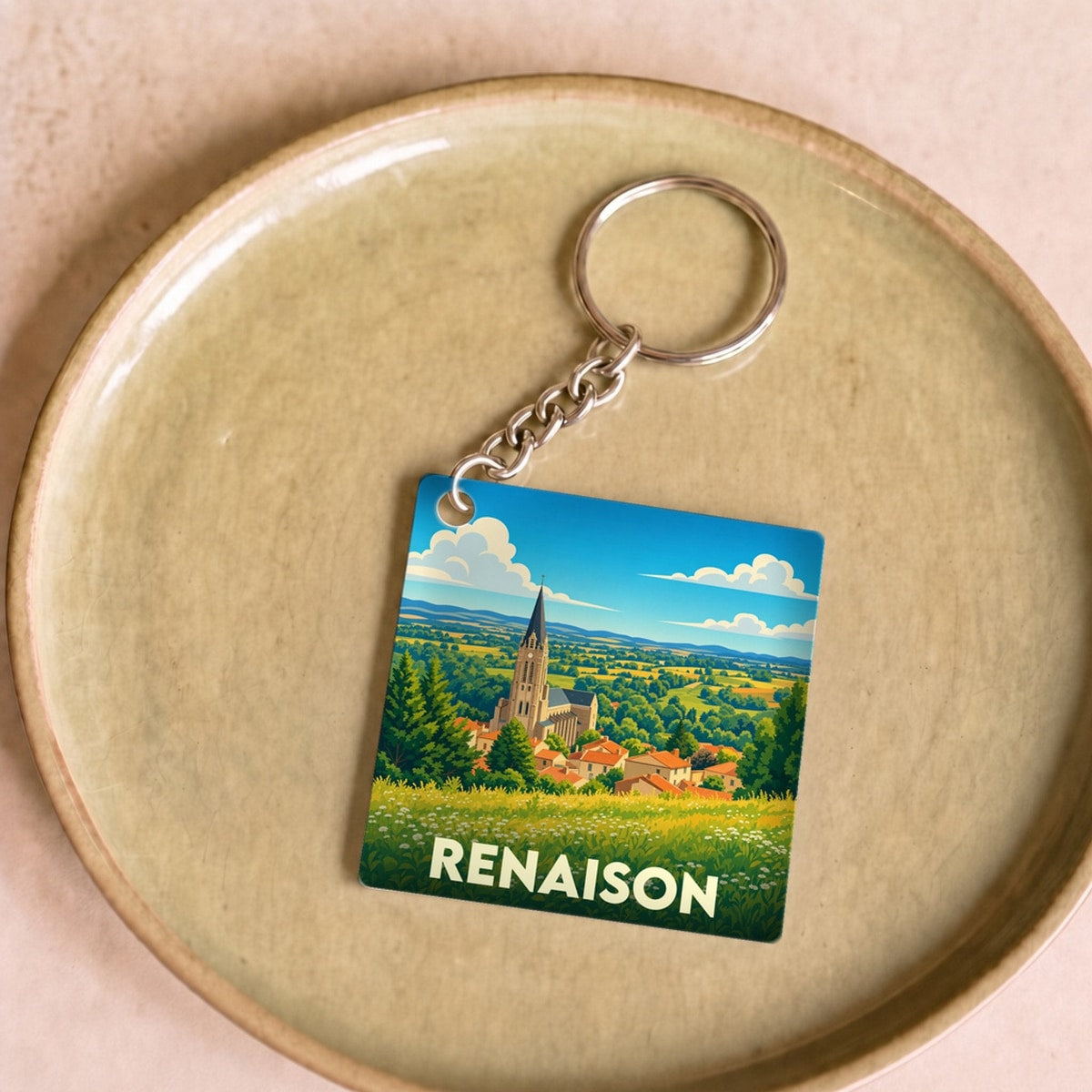 Porte-clés souvenir de la ville de Renaison avec une illustration stylisée.