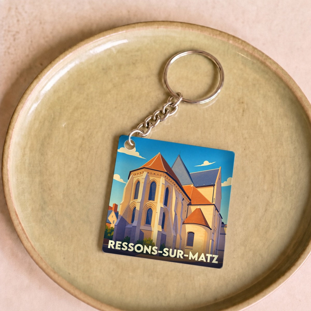 Porte-clés souvenir de la ville de Ressons-sur-Matz avec une illustration stylisée d'une église.