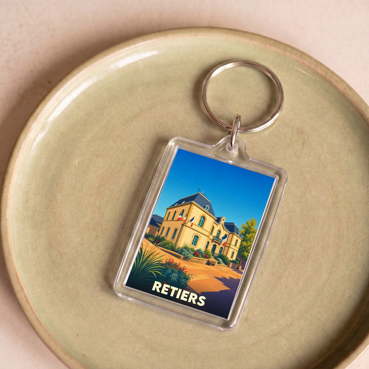 Porte-clés souvenir de la ville de Retiers avec une illustration stylisée de son hôtel de ville.