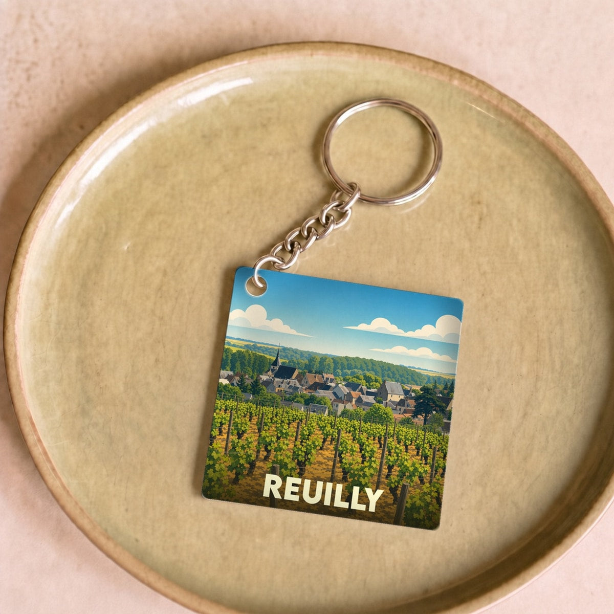 Porte-clés souvenir de la ville de Reuilly avec une illustration stylisée de ses vignobles.