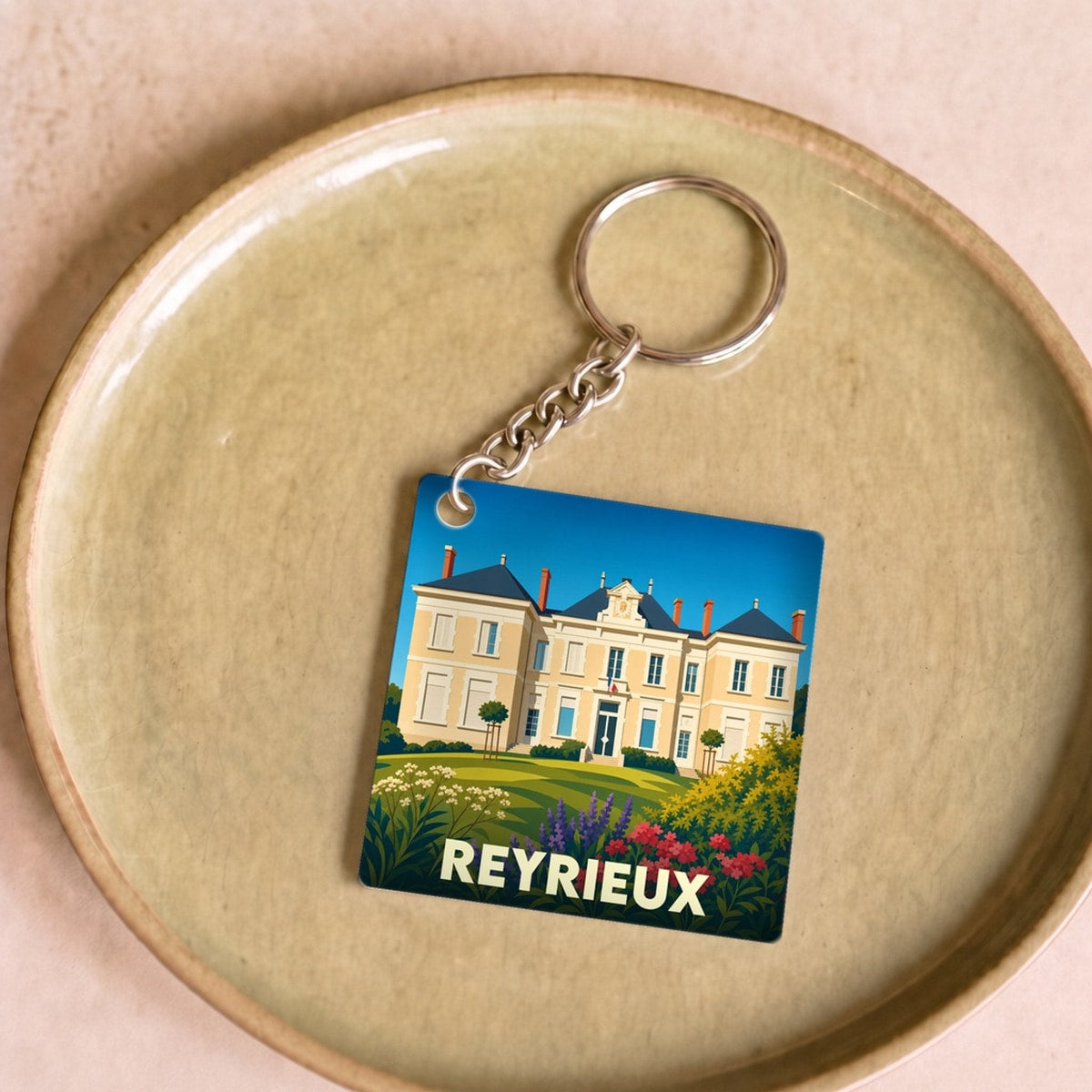 Porte-clés souvenir de la ville de Reyrieux avec une illustration stylisée de son château.