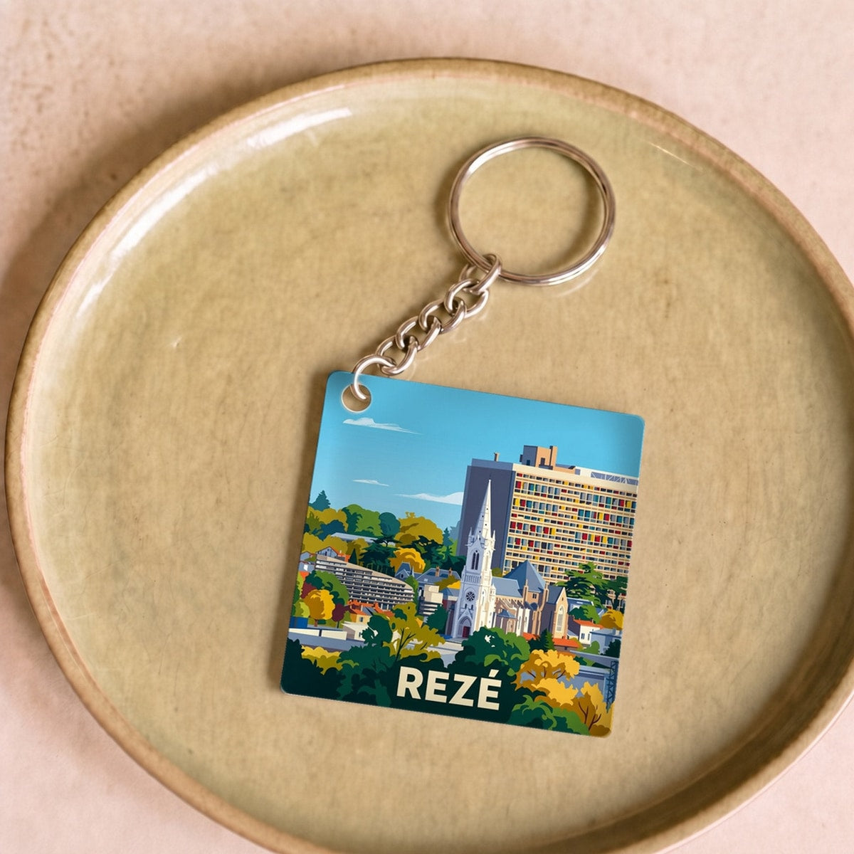 Porte-clés souvenir de la ville de Rezé avec une illustration stylisée.