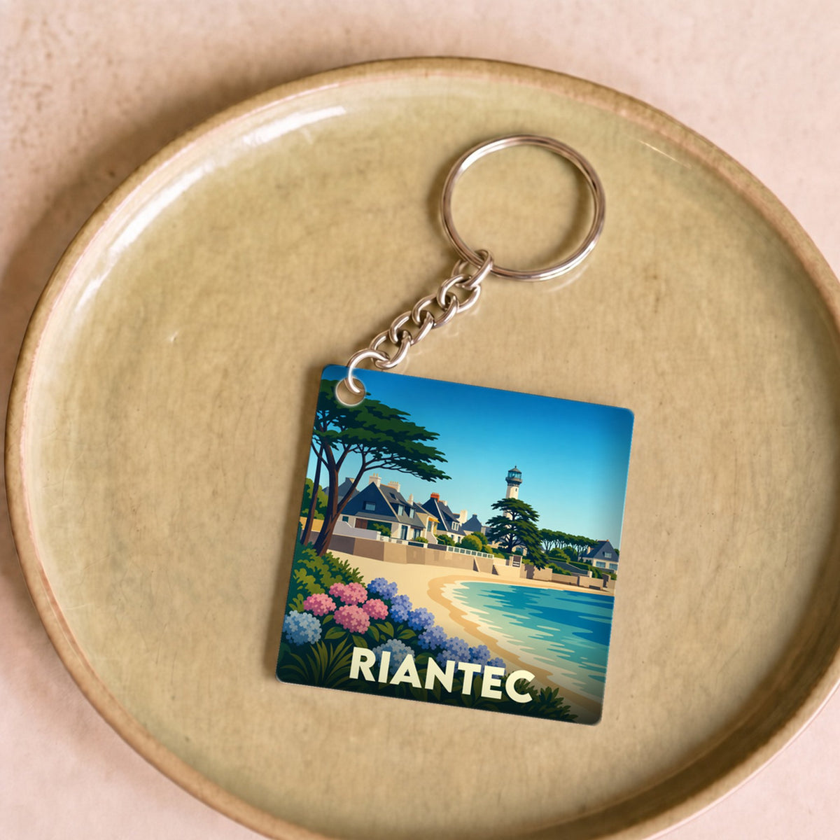 Porte-clés souvenir de la ville de Riantec avec une illustration stylisée du bord de mer.