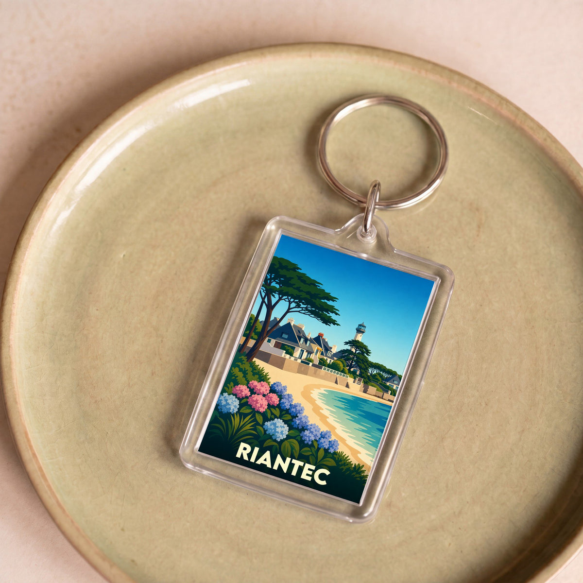 Porte-clés souvenir de la ville de Riantec avec une illustration stylisée du bord de mer.
