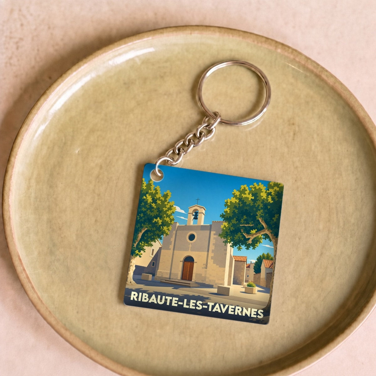 Porte-clés souvenir de la ville de Ribaute-les-Tavernes avec une illustration stylisée.