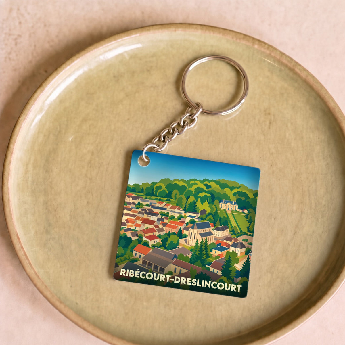 Porte-clés souvenir de la ville de Ribécourt-Dreslincourt avec une illustration stylisée.