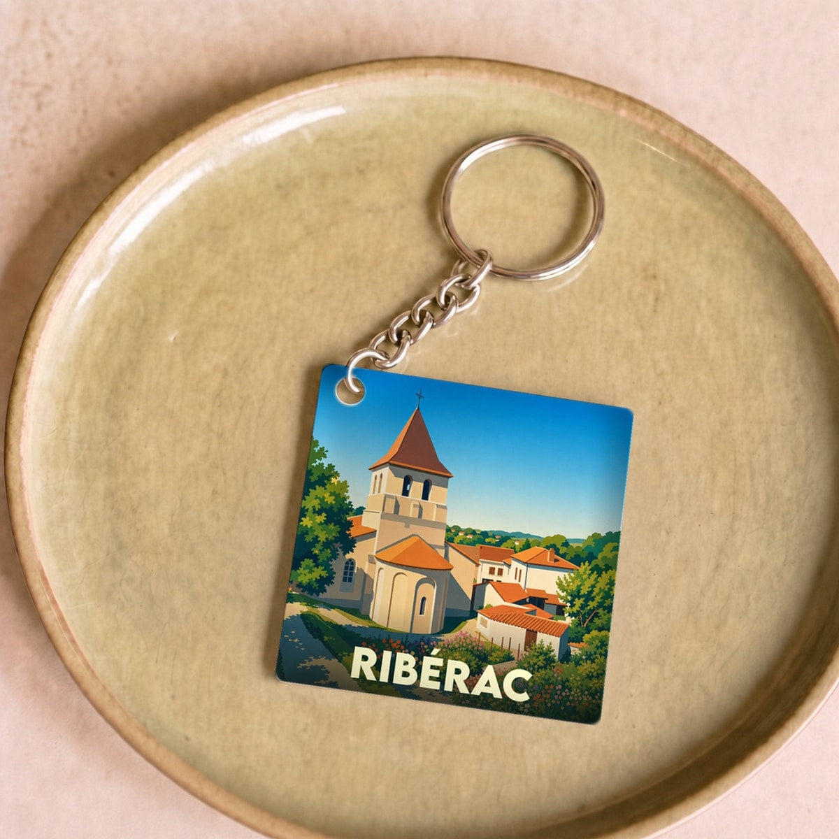 Porte-clés souvenir de la ville de Ribérac avec une illustration stylisée de son église.