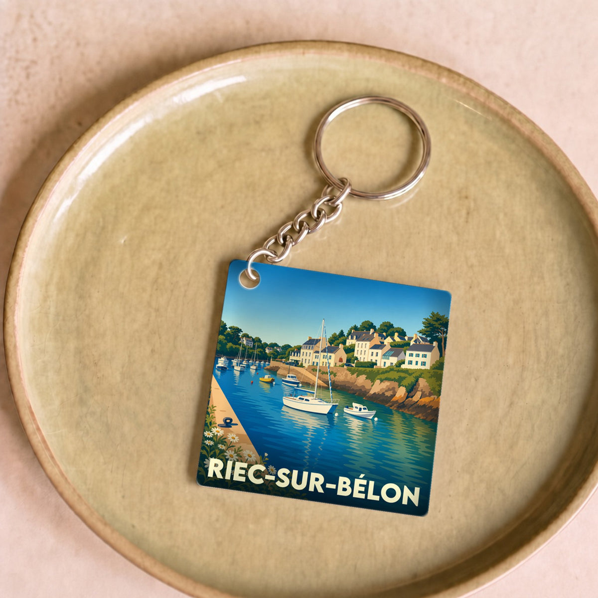 Porte-clés souvenir de la ville de Riec-sur-Bélon avec une illustration stylisée d'un port breton.