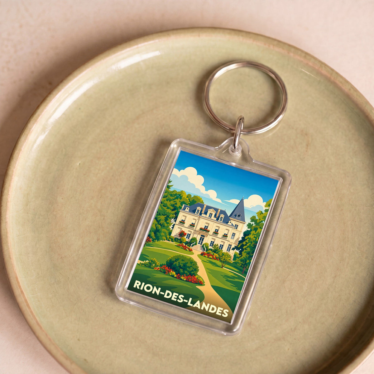 Porte-clés souvenir de la ville de Rion-des-Landes avec une illustration stylisée d'un château.
