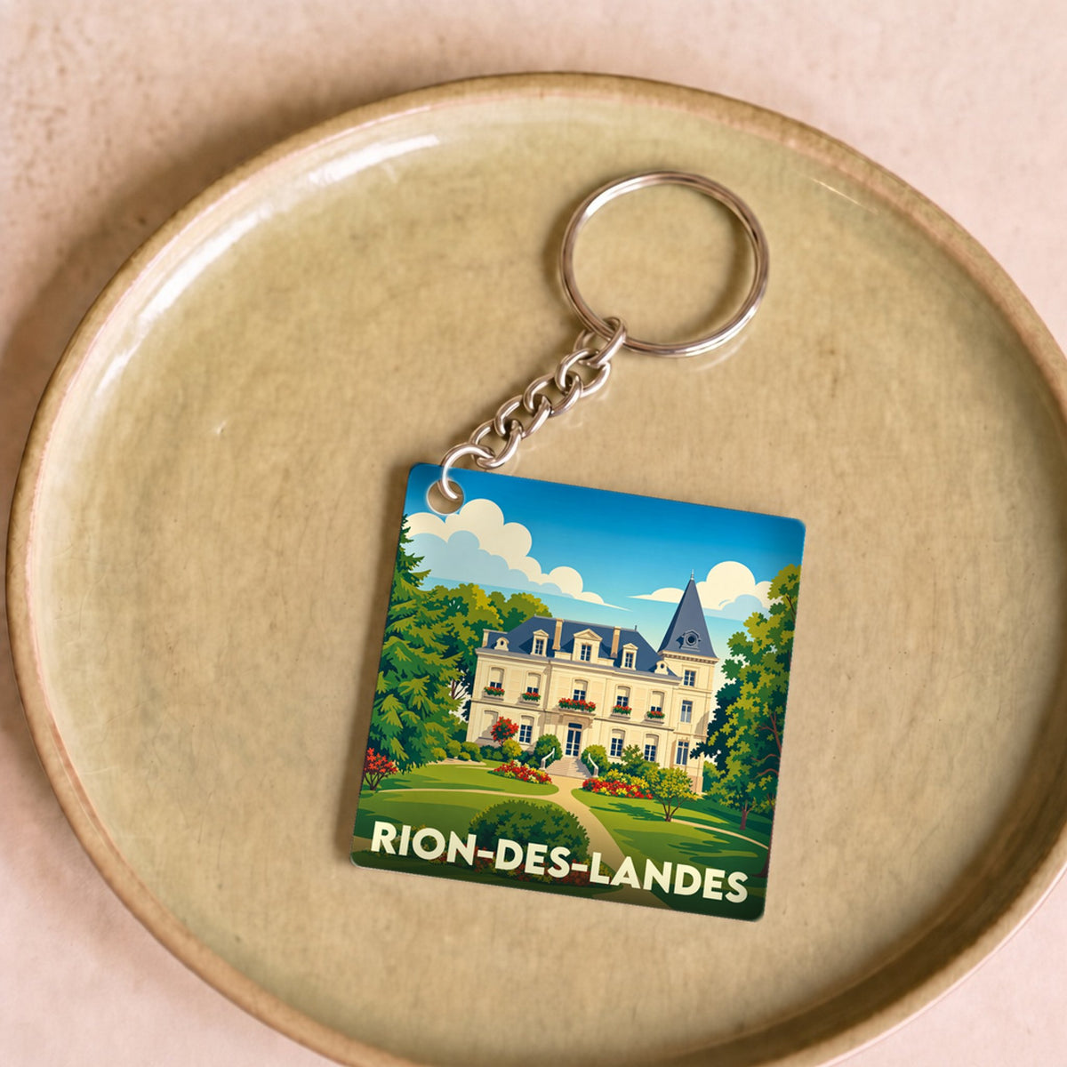 Porte-clés souvenir de la ville de Rion-des-Landes avec une illustration stylisée d'un château.