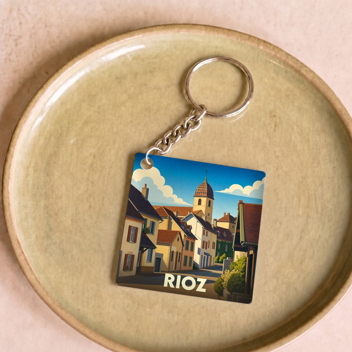 Porte-clés souvenir de la ville de Rioz avec une illustration stylisée.