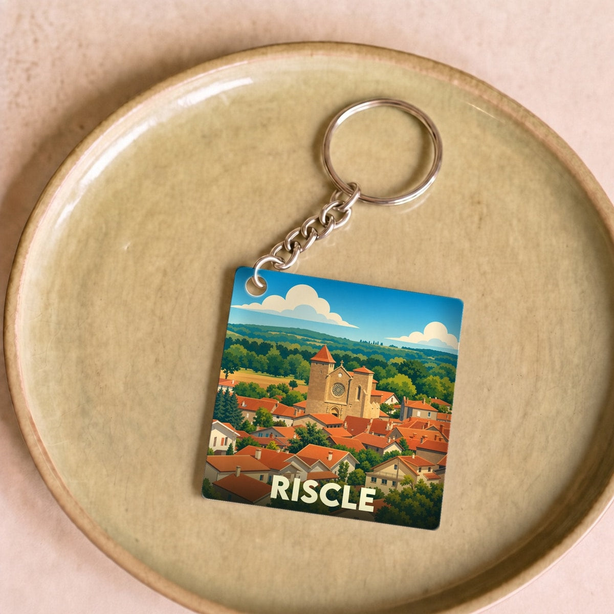 Porte-clés souvenir de la ville de Riscle avec une illustration stylisée.
