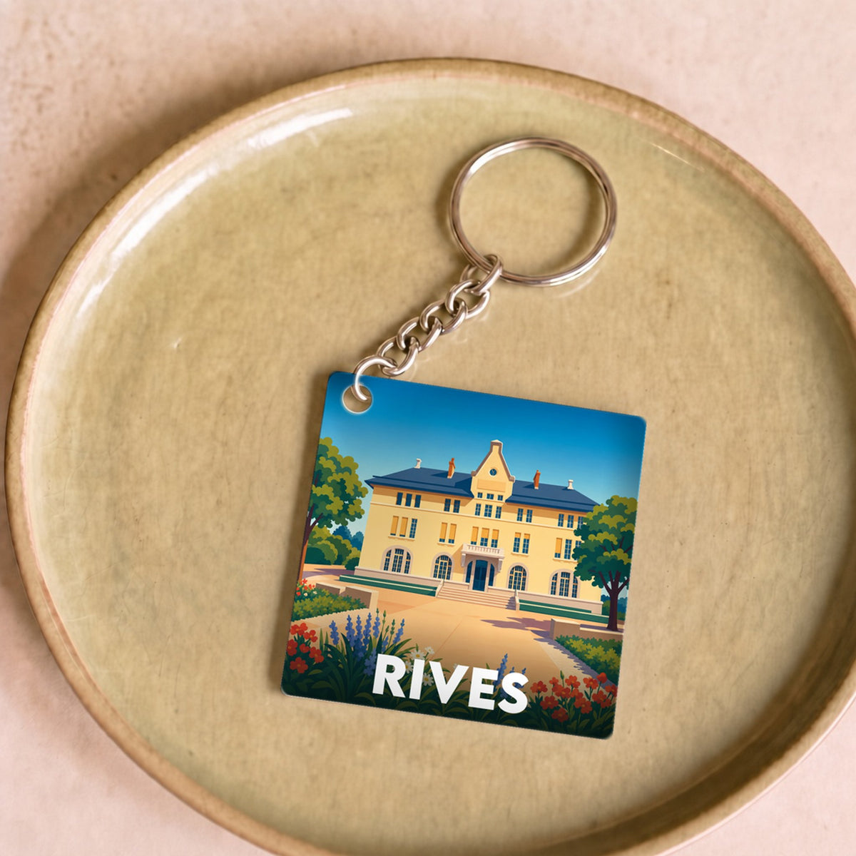 Porte-clés souvenir de la ville de Rives avec une illustration stylisée.