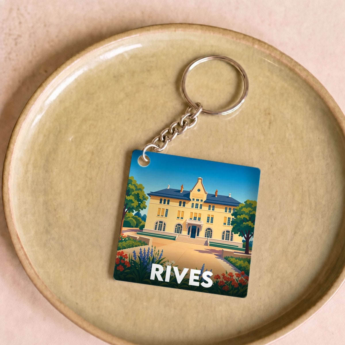 Porte-clés souvenir de la ville de Rives avec une illustration stylisée.