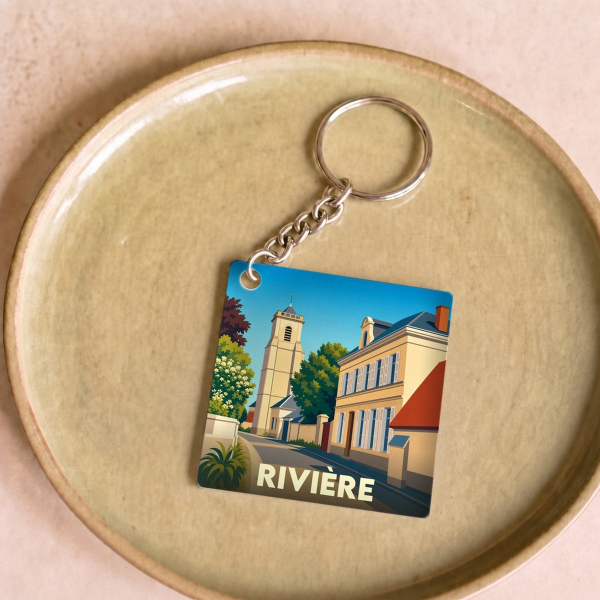 Porte-clés souvenir de la ville de Rivière avec une illustration stylisée.