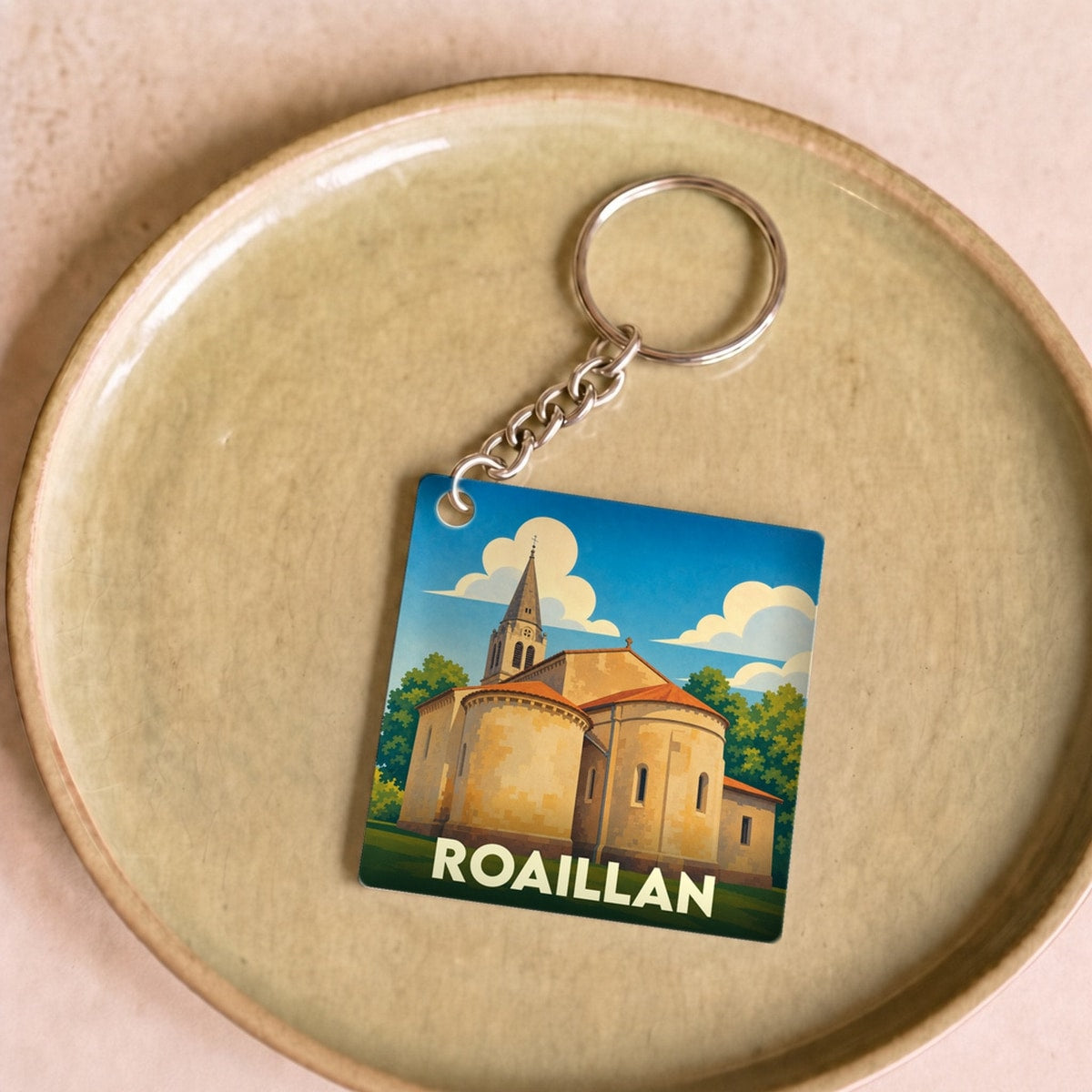 Porte-clés souvenir de la ville de Roaillan avec une illustration stylisée de son église.
