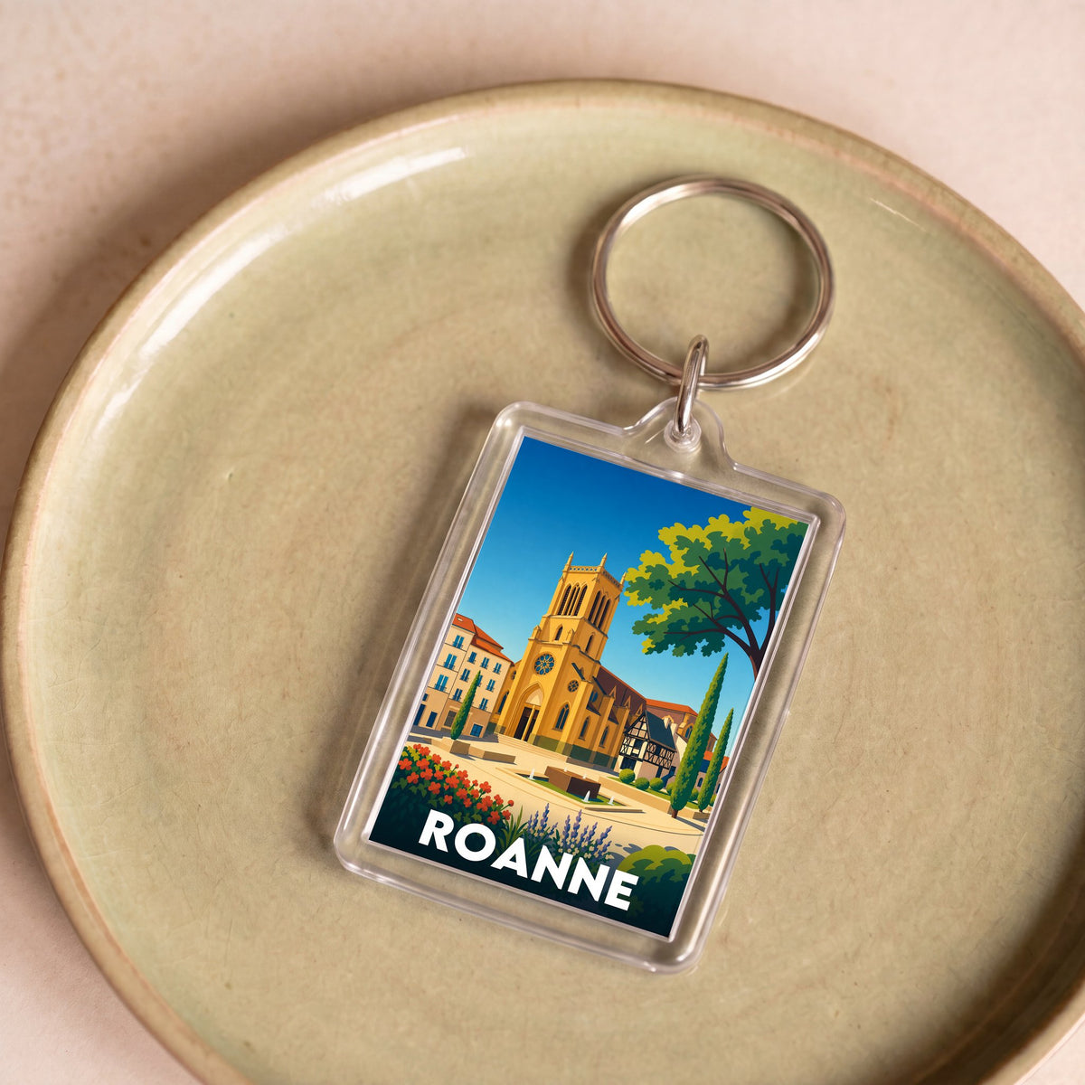 Porte-clés souvenir de la ville de Roanne avec une illustration stylisée.