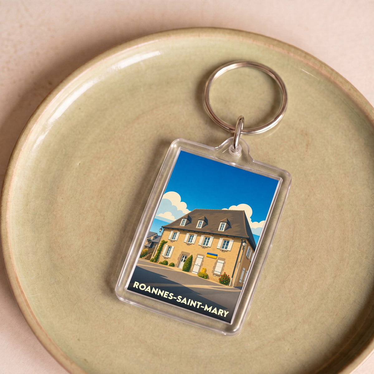 Porte-clés souvenir de la ville de Roannes-Saint-Mary avec une illustration stylisée.
