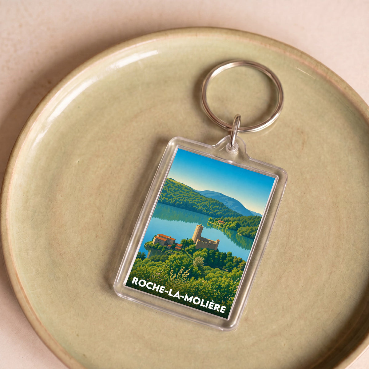 Porte-clés souvenir de la ville de Roche-la-Molière avec une illustration paysagère stylisée.