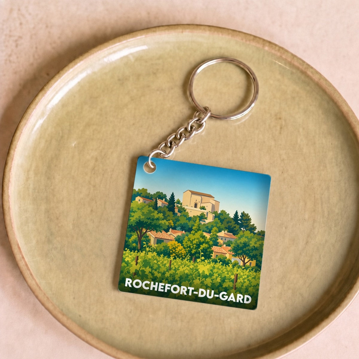 Porte-clés souvenir de la ville de Rochefort-du-Gard avec une illustration stylisée.