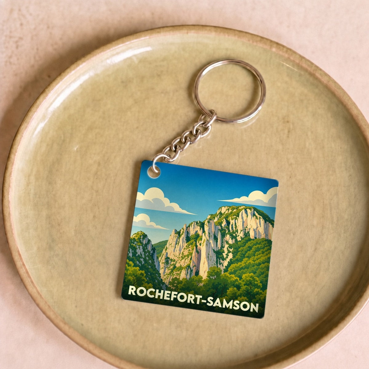 Porte-clés souvenir de la ville de Rochefort-Samson avec une illustration stylisée.