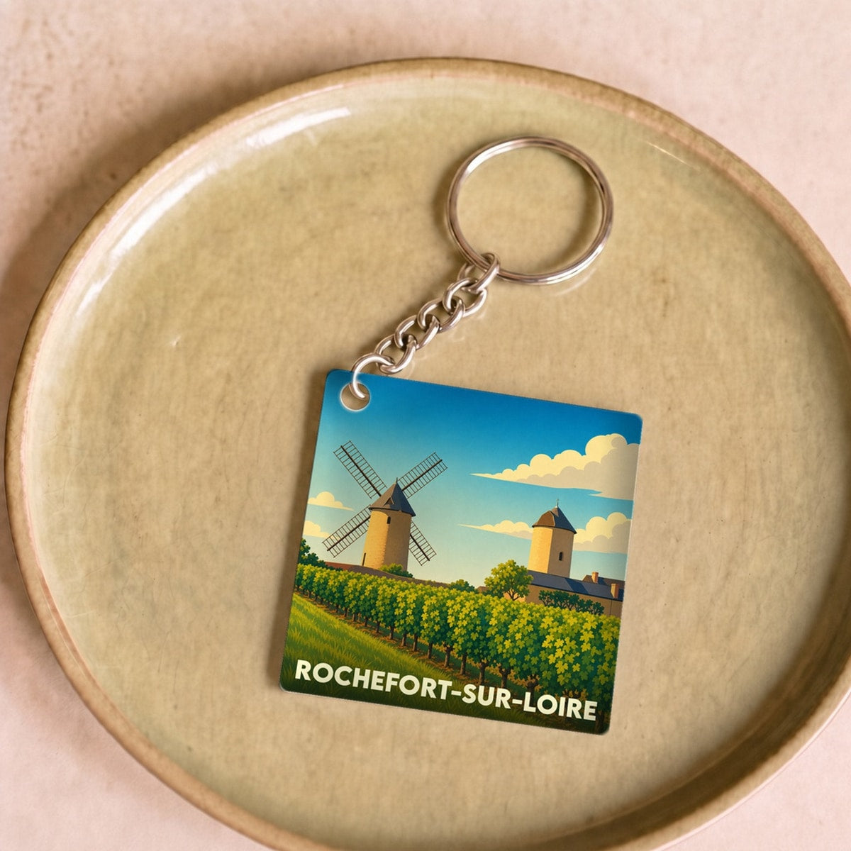 Porte-clés souvenir de la ville de Rochefort-sur-Loire avec une illustration stylisée de moulins et de vignes.