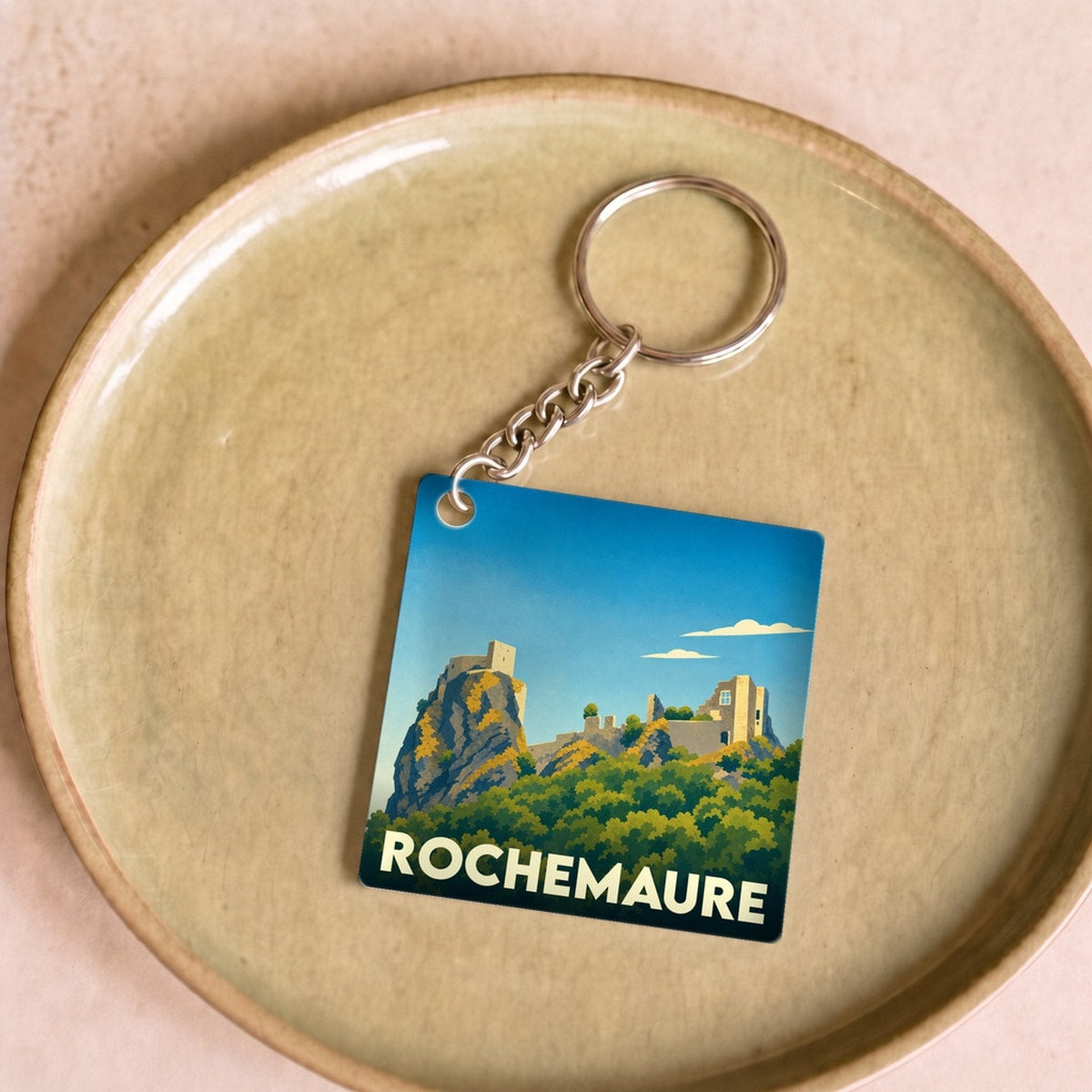 Porte-clés souvenir de la ville de Rochemaure avec une illustration stylisée de son château.