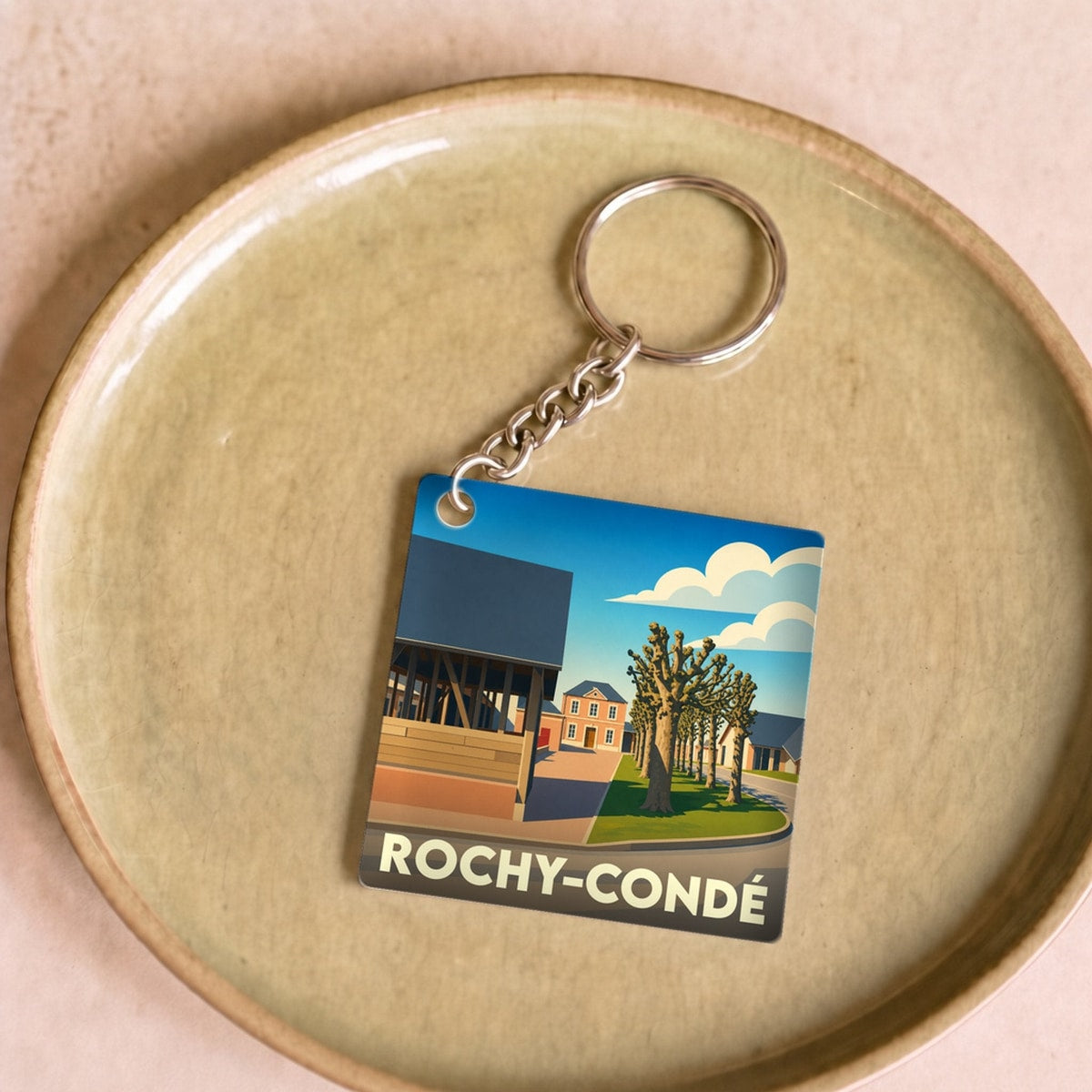 Porte-clés souvenir de la ville de Rochy-Condé avec une illustration stylisée.