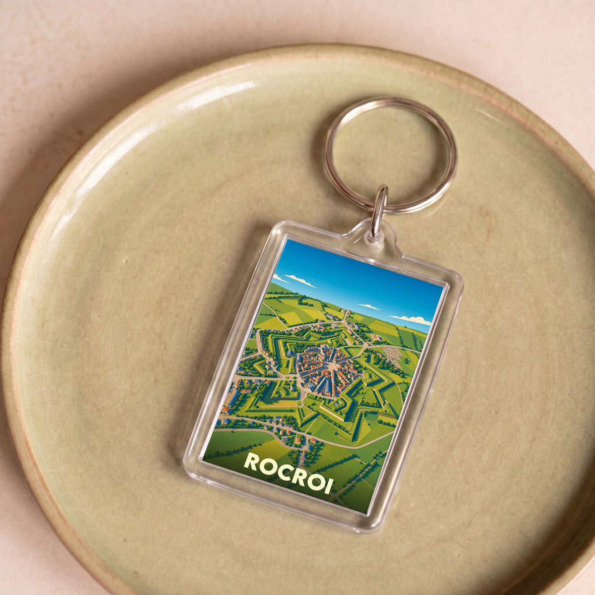 Porte-clés souvenir de la ville de Rocroi avec une illustration stylisée vue du ciel.