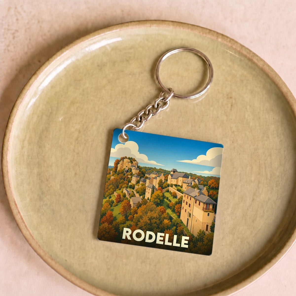 Porte-clés souvenir de la ville de Rodelle avec une illustration stylisée.