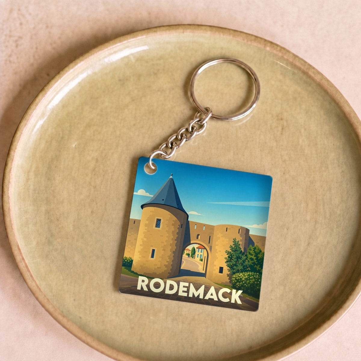 Porte-clés souvenir de la ville de Rodemack avec une illustration stylisée de ses remparts médiévaux.