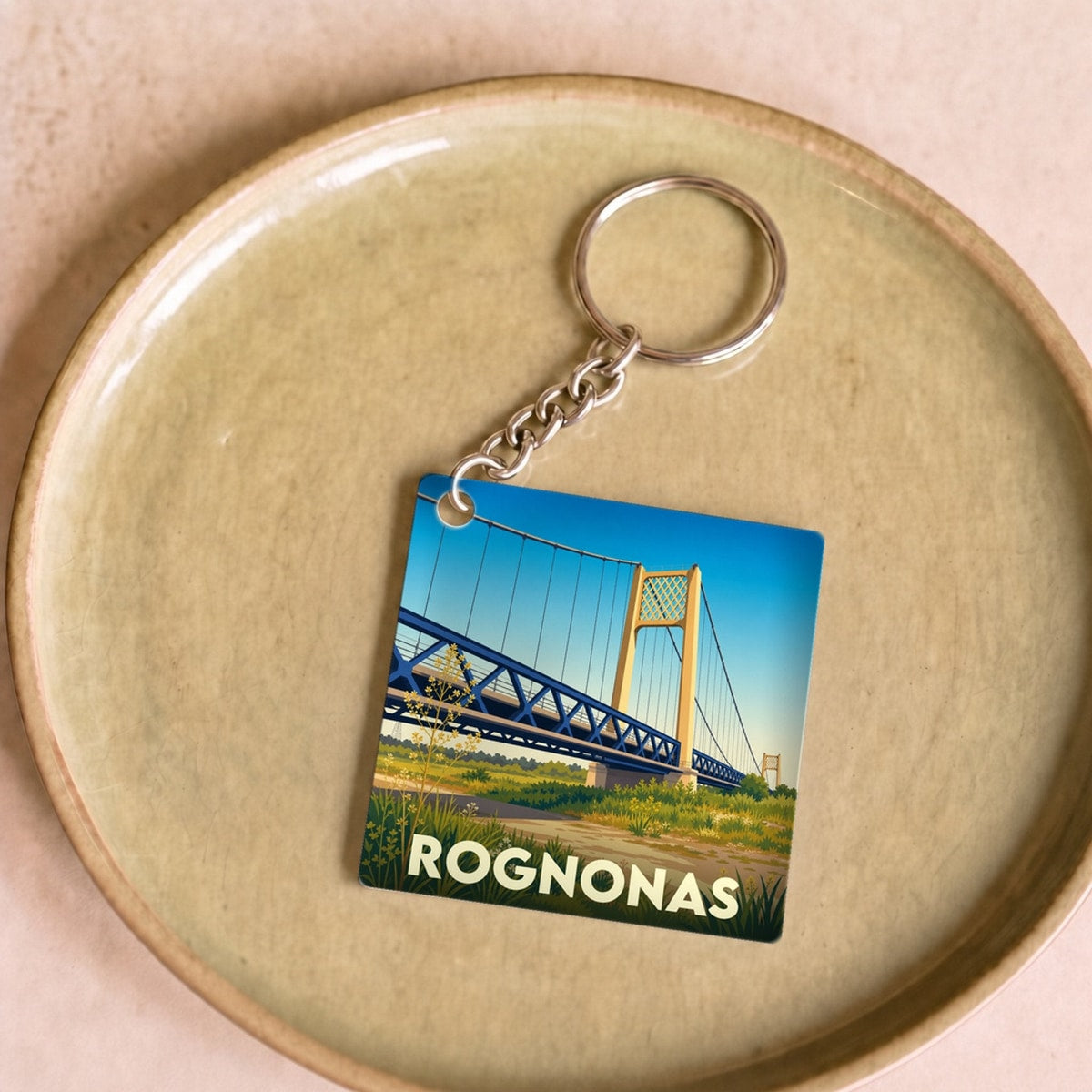 Porte-clés souvenir de la ville de Rognonas avec une illustration stylisée de son pont suspendu.