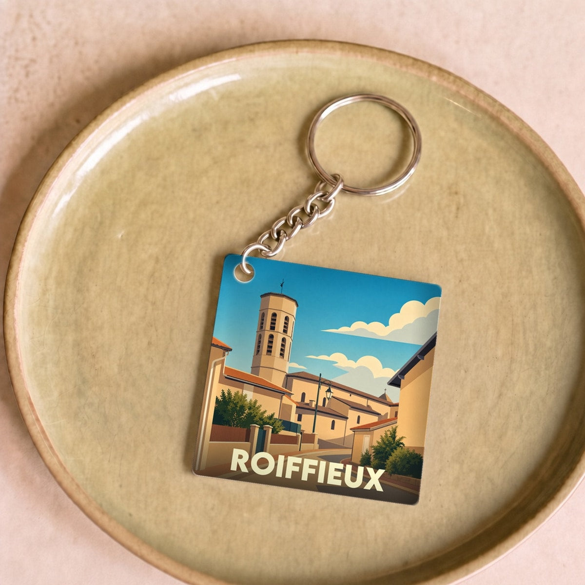 Porte-clés souvenir de la ville de Roiffieux avec une illustration stylisée.