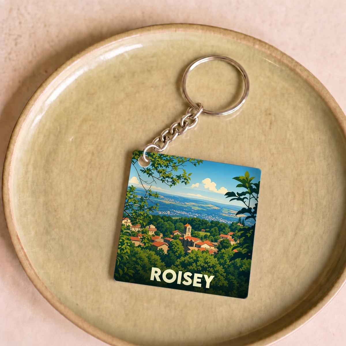 Porte-clés souvenir de la ville de Roisey avec une illustration stylisée de son paysage.