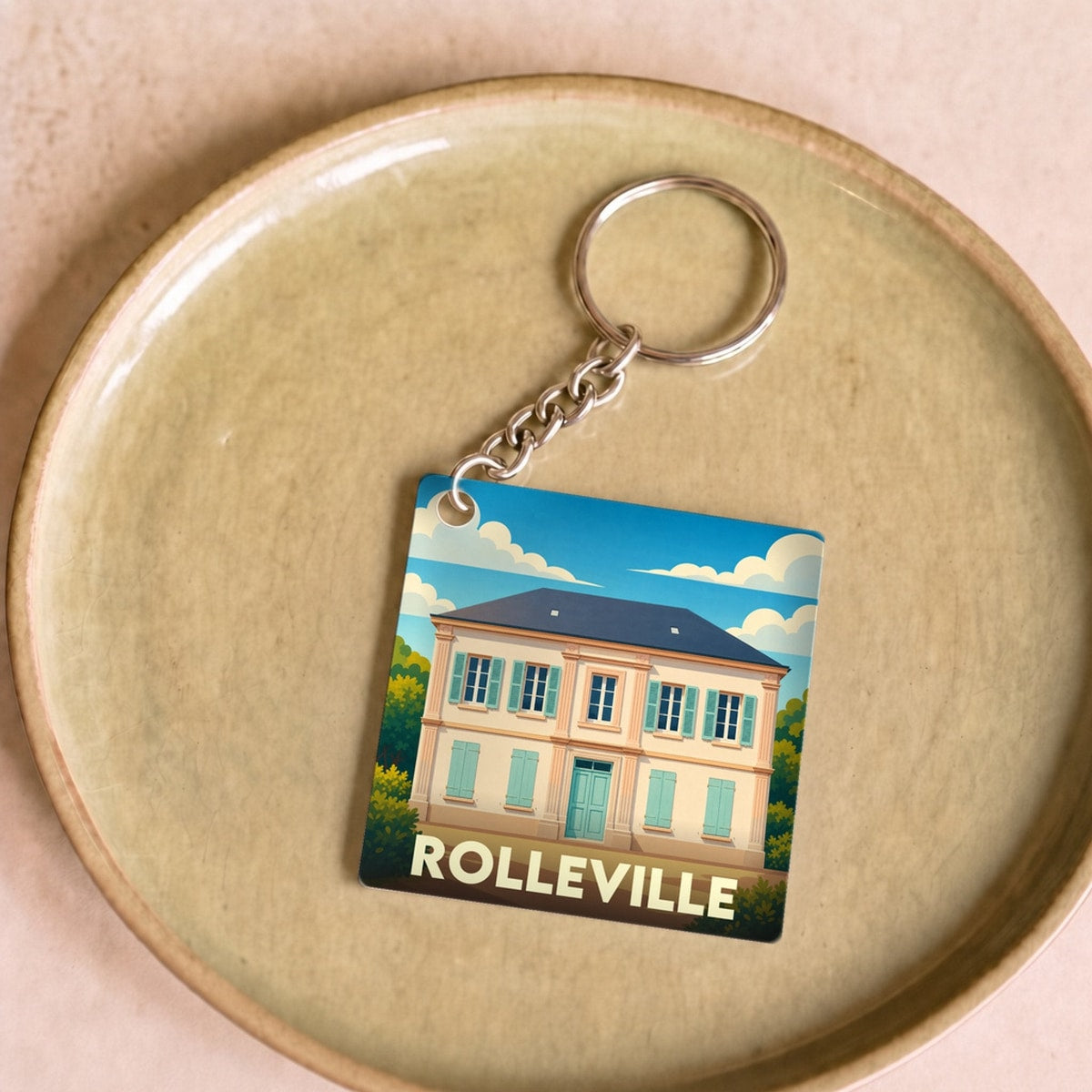 Porte-clés souvenir de la ville de Rolleville avec une illustration stylisée d'une maison de maître.