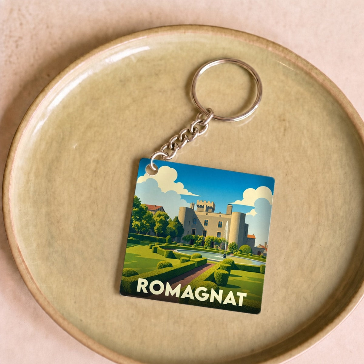 Porte-clés souvenir de la ville de Romagnat avec une illustration stylisée de son château.