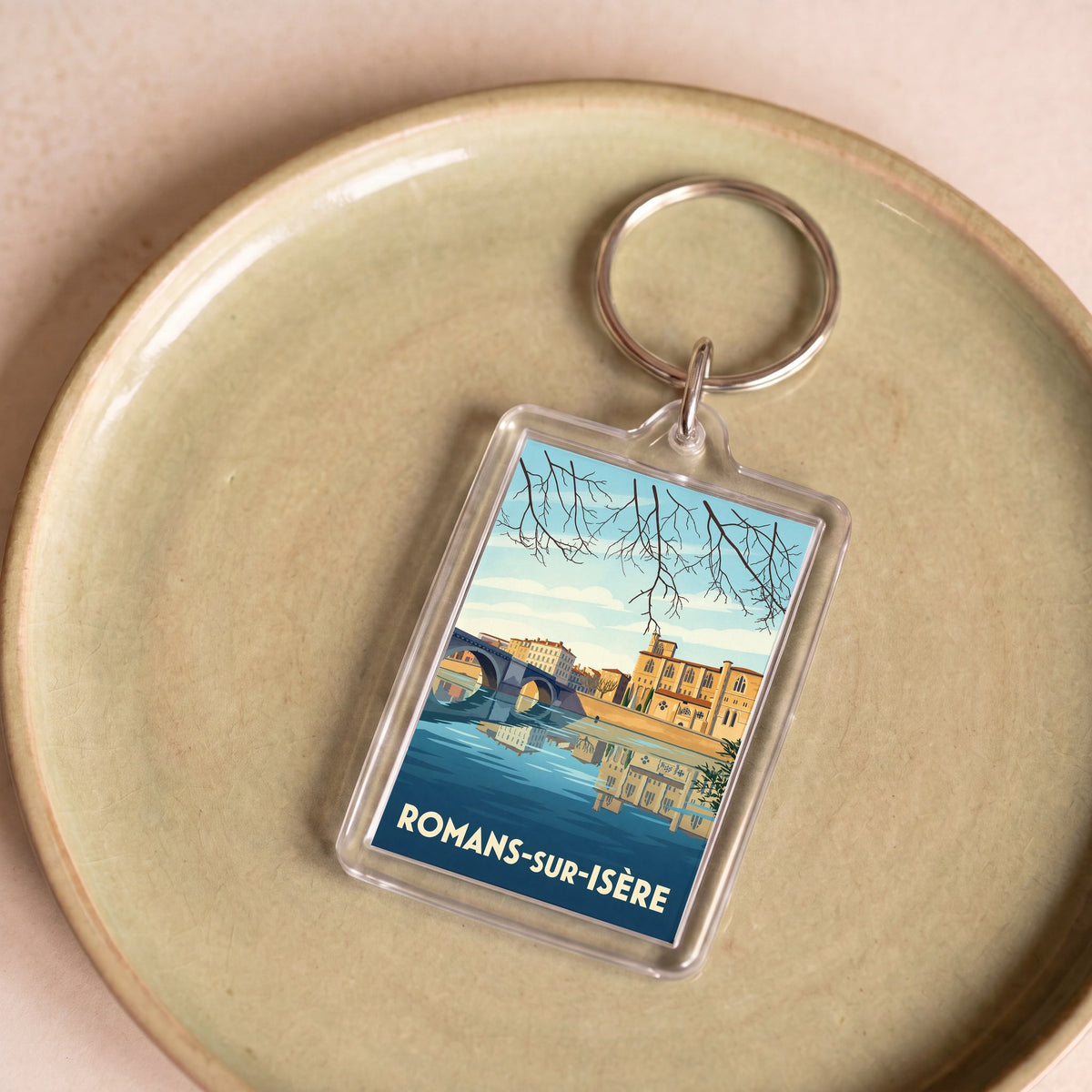 Porte-clés souvenir de la ville de Romans-sur-Isère avec une illustration stylisée.