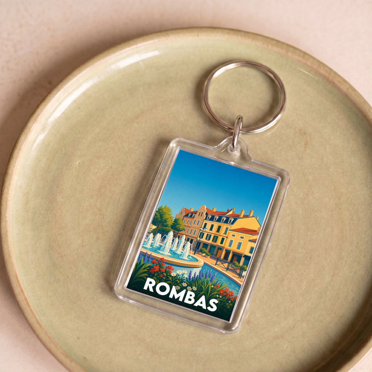 Porte-clés souvenir de la ville de Rombas avec une illustration stylisée d'une place animée.