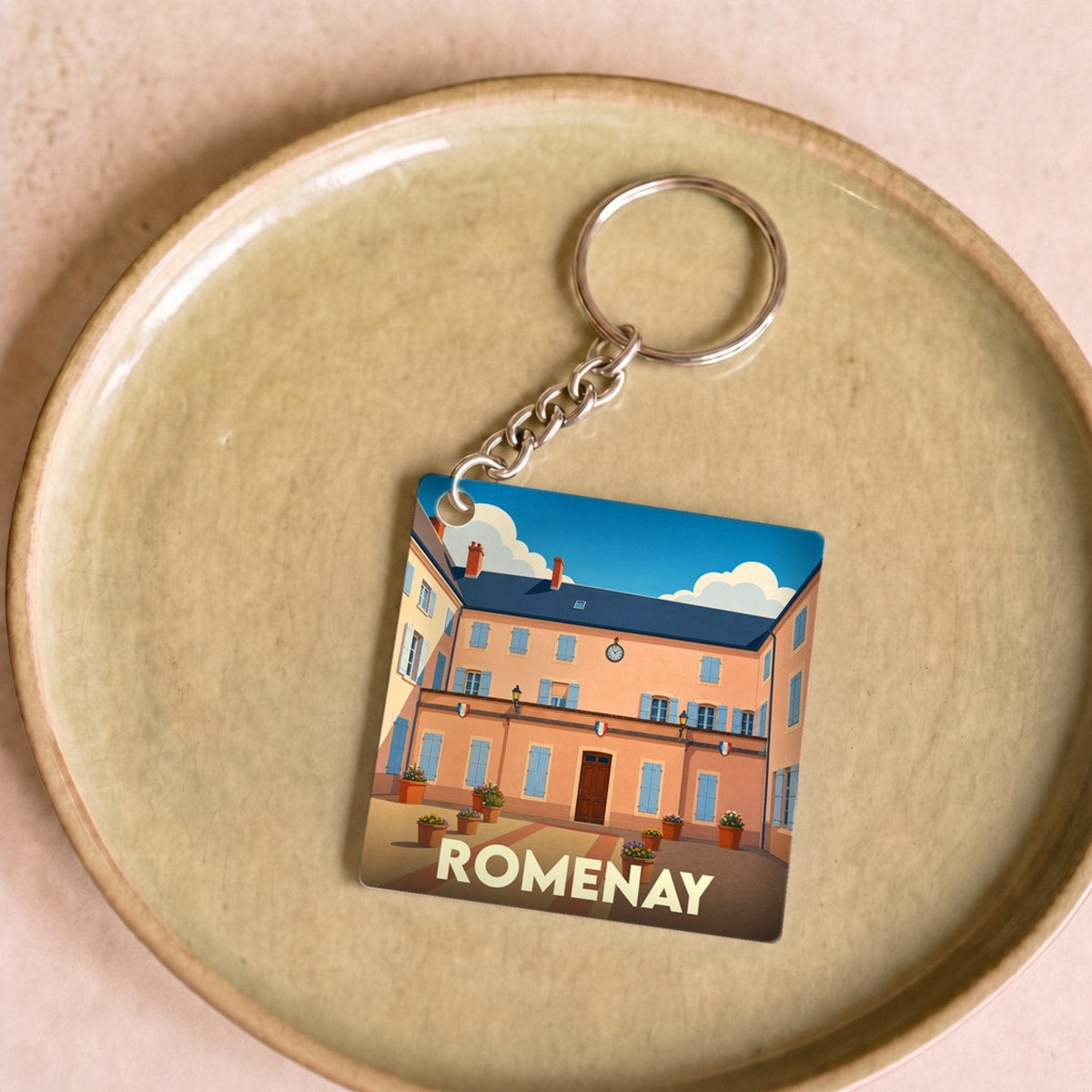 Porte-clés souvenir de la ville de Romenay avec une illustration stylisée de sa mairie.