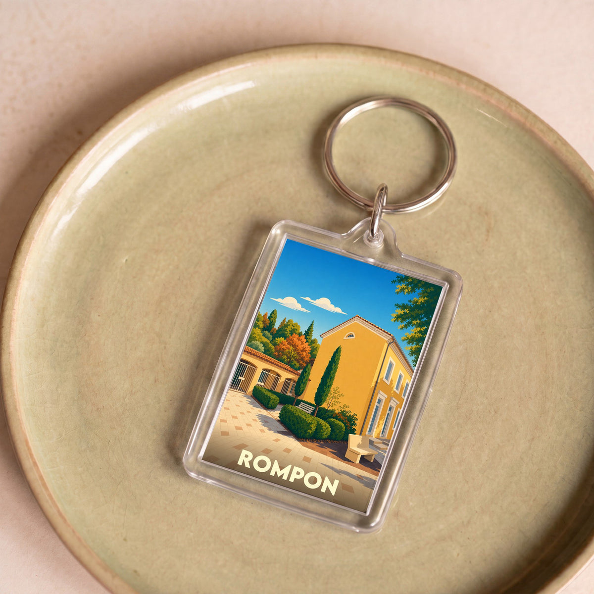 Porte-clés souvenir de la ville de Rompon avec une illustration stylisée.
