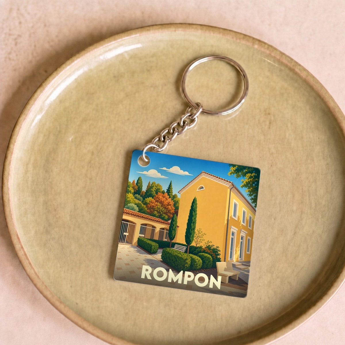 Porte-clés souvenir de la ville de Rompon avec une illustration stylisée.