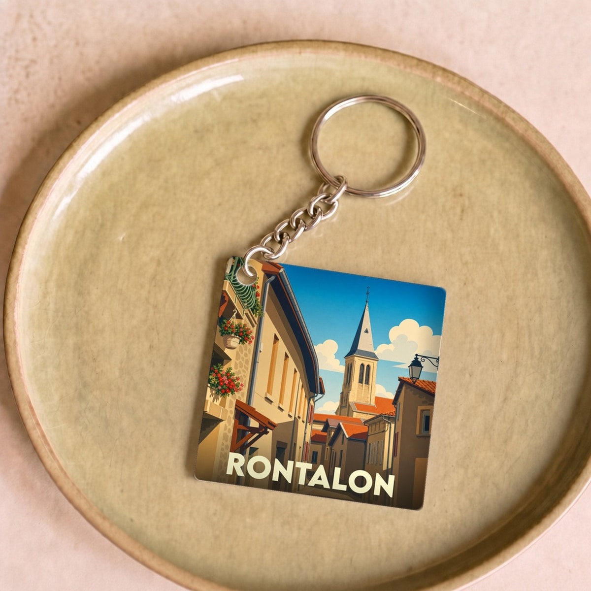 Porte-clés souvenir de la ville de Rontalon avec une illustration stylisée de ses rues et de son clocher.