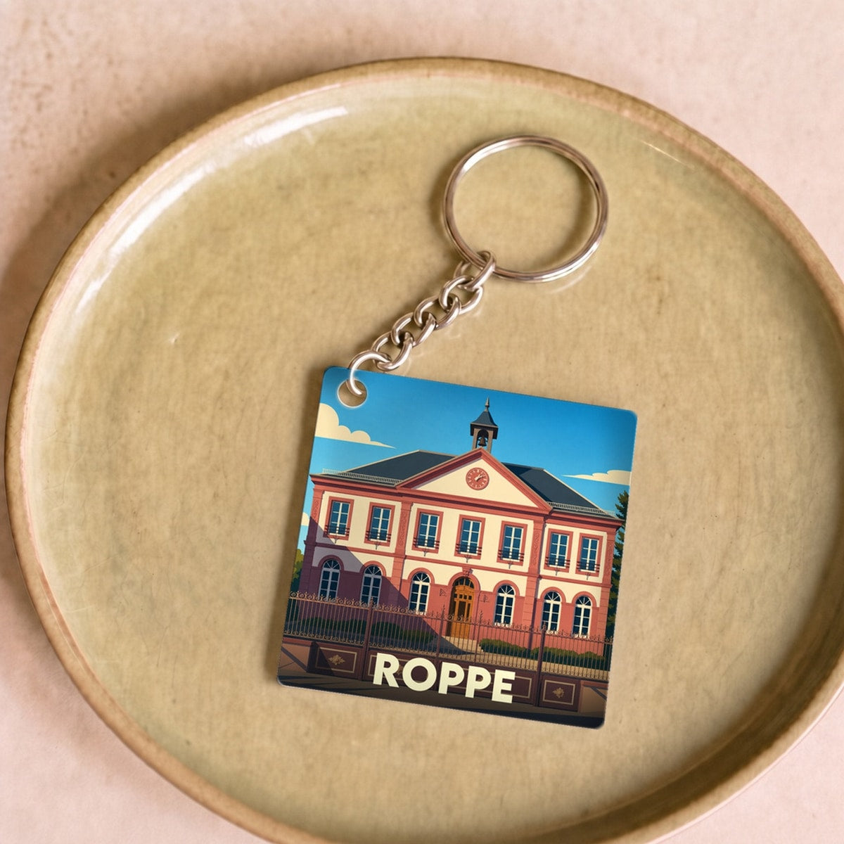 Porte-clés souvenir de la ville de Roppe avec une illustration stylisée de sa mairie.